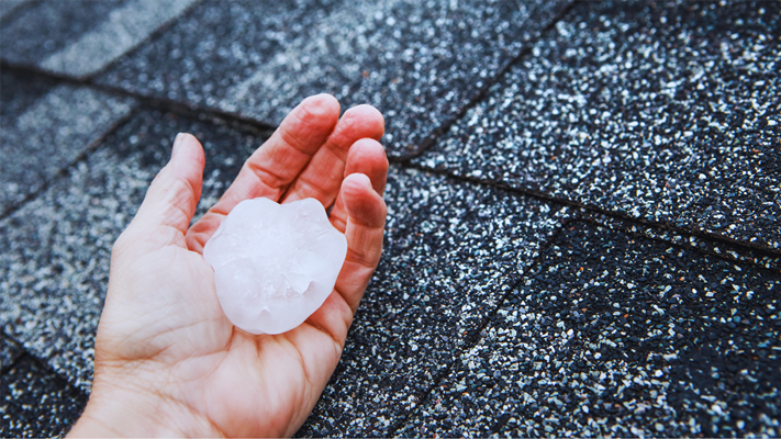 A man holding a piece of hail that fell on his roof in NJ.